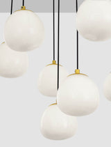 Pendelleuchte THE EGG mit opalen Glasschirmen, modernes Design in Gold und Schwarz, ideal für stilvolle Innenräume.