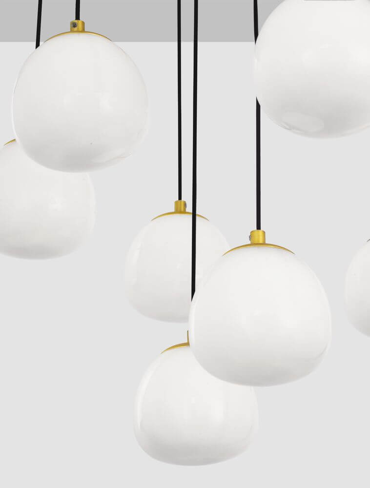 Moderne Pendelleuchte mit mundgeblasenen weißen Glasschirmen und goldenen Details, ideal für stilvolle Innenräume.