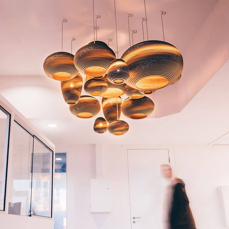 Jazzy lampe à suspendre en carton ovale dans un intérieur moderne, éclairage design durable au caractère unique.