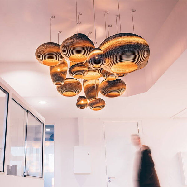 Jazzy Hängelampe aus Karton oval im modernen Innenraum, nachhaltige Designbeleuchtung mit einzigartigem Charakter.