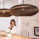 Jazzy Hängelampe aus Karton oval im modernen Interieur mit stilbewusster Frau am Tisch.