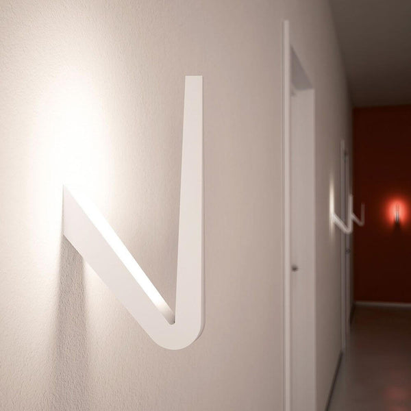 Aplique de pared Rotaliana Tick LED de 29 cm en blanco instalado en una pared en una estancia moderna.