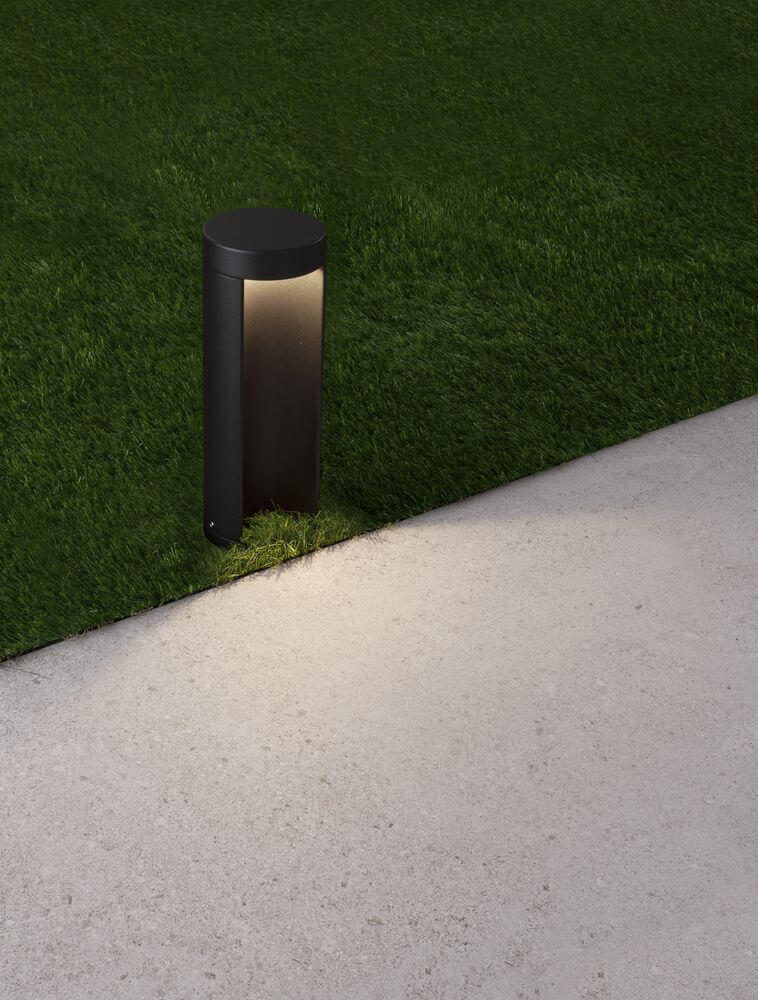 Tien LED Außensockelleuchte 3000K Schwarz IP54 auf einem Weg mit Gras im Hintergrund.