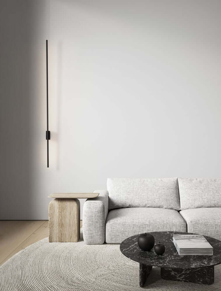 Tien LED Wandleuchte Versetzt 90/30cm 3000K Schwarz über einem modernen Sofa in stilvollem Raum.
