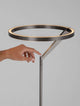 Tilia LED Stehlampe H 168cm 3000K mit Hand, die den Leuchtkreis berührt, modernes Design aus Aluminium.