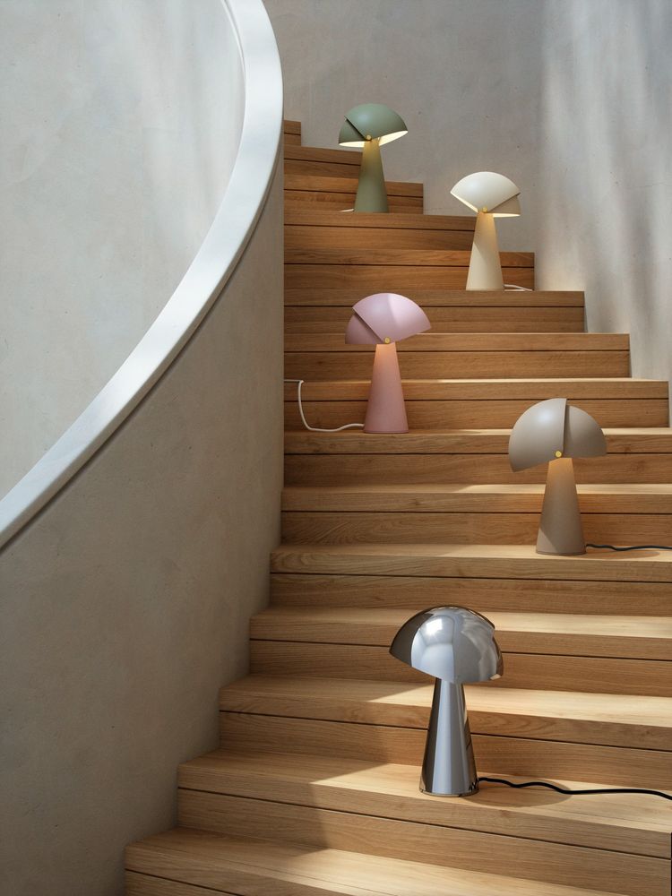 Moderne Tischlampen von Maria Berntsen auf einer Treppe, in eleganten Farben angeordnet.