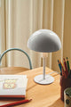 Tischlampe Ellen Mini auf einem Tisch, ideal für Kinderzimmer und kleine Räume.