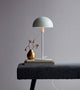 Tischlampe Ellen Weiß auf einem Tisch mit dekorativen Elementen und elegantem, modernem Design.