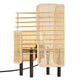 Tischlampe Jaffna mit modernem Design aus Rattan und schwarzem Fuß, ideal für stimmungsvolle Beleuchtung.