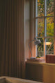 Tischlampe Matis auf einem Fenstersims, ideal für Schreibtisch und minimalistische Einrichtung.