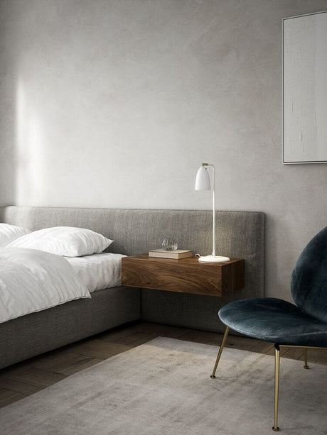 Tischlampe Nexus 2 neben einem modernen Bett in einem minimalistisch eingerichteten Schlafzimmer.