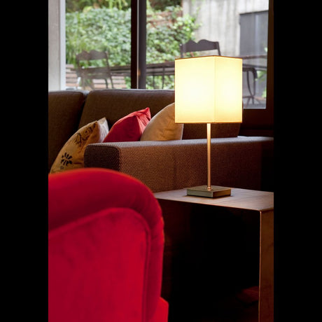 Tischlampe THANA Nickel, Weiß auf Beistelltisch in modernem Wohnzimmer mit roten und beigen Kissen.