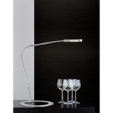 Moderne Schreibtischlampe Plaza 3W LED mit flexibler Gelenke und stilvollem Design auf einem Tisch mit Gläsern.