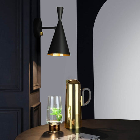 Tom Dixon Beat Wandleuchte verstellbar mit Dimmer über einem Tisch mit Glas und Kanne.