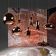 Tom Dixon Copper Pendelleuchte, hochwertige metallische Lampen im modernen Design auf farbigem Hintergrund.