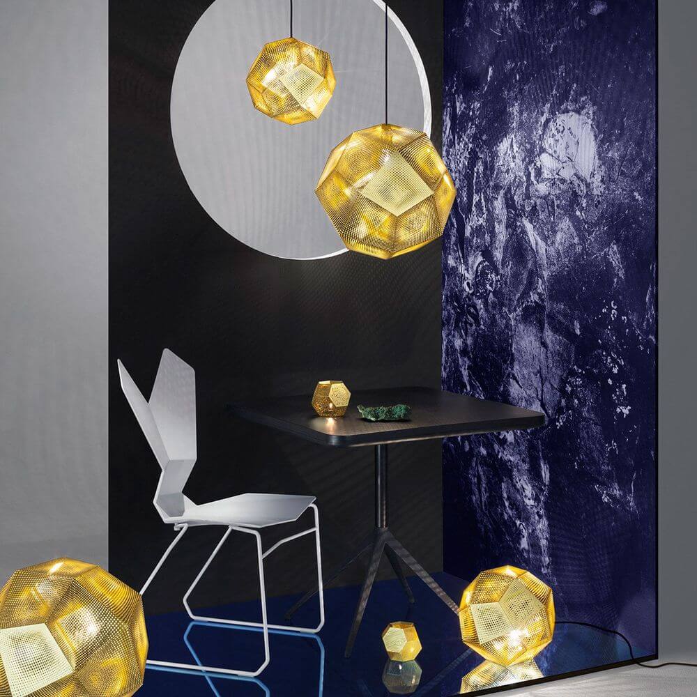 Tom Dixon Etch Metall Hängeleuchte Effektlicht in einem modernen Raum mit geometrischen Formen und einem Tisch.