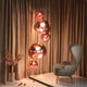 Tom Dixon Melt LED organische Pendellampe in einem eleganten Raum mit gemütlichem Sessel und Vorhängen.