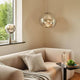 Tom Dixon Melt LED organische Pendellampe in modernem Wohnraum mit Sofa und gläsernen Deko-Elementen.