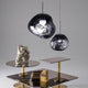 Tom Dixon Melt LED organische Pendellampe in unregelmäßiger Form über modernem Beistelltisch.