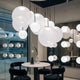 Tom Dixon Opal Kugelleuchte Pendel in modernem Raum mit minimalistischer Einrichtung.
