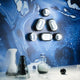 Tom Dixon Spot Wandleuchte mit Glaslinse an blauer Wand mit kreativem Design.