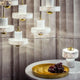 Tom Dixon Stone Tischlampe aus Marmor auf einem Tisch mit goldenem Tablett und Trauben.