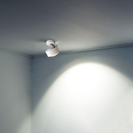 LED Deckenstrahler Puk Maxx Move 360° in elegantem Design an der Decke installiert, strahlt Licht auf die Wand.