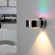 LED Wandleuchte Puk Maxx Wall Dimmbar an einer Wand installiert, modernes und klares Design mit RGB-Lichtakzent.