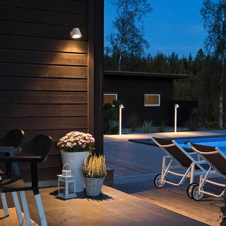 Trieste outdoor wall light white, clear acrylic glass, reflector illuminates a modern terrace.