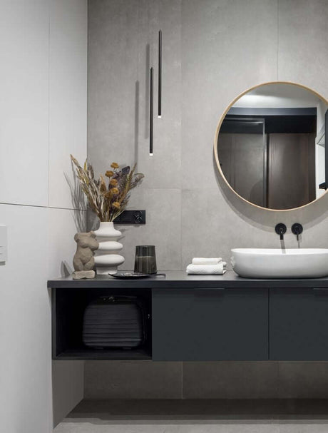 Moderne Badezimmeransicht mit Trimle LED Pendelleuchte H 70cm Ø 2,5cm 3000K über Waschbecken und stilvollen Accessoires.