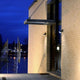 Trumpet L 90° schwenkbare LED-Außenwandleuchte IP54 Anthrazit an einer modernen Fassade bei Nacht.