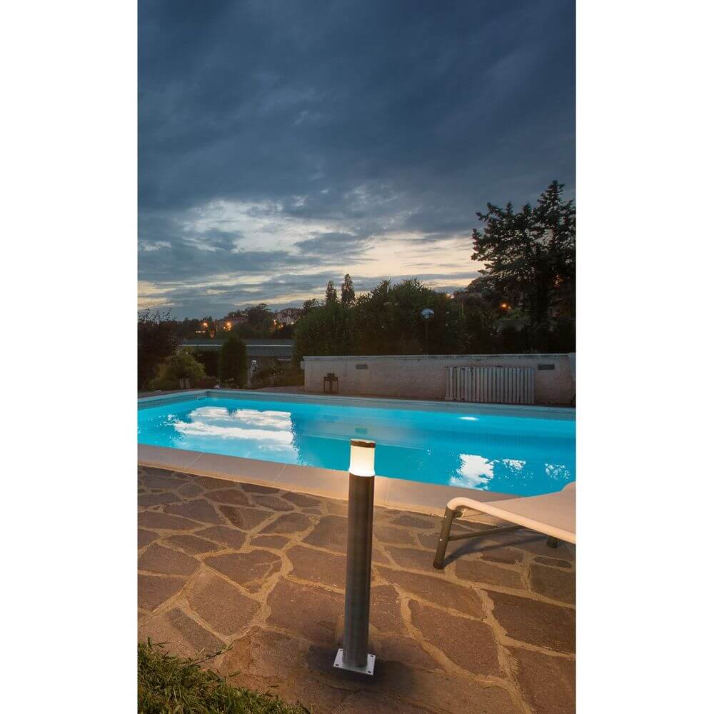 Trust 60 LED Außen-Stehleuchte Edelstahl neben einem beleuchteten Pool bei Dämmerung.