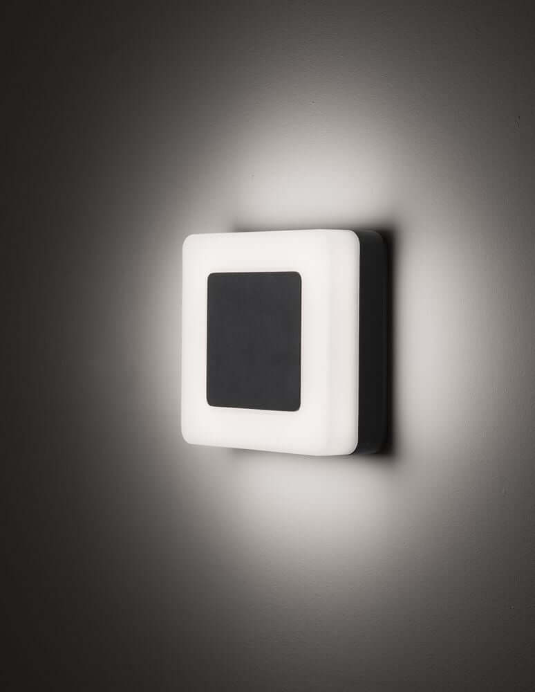 Tune LED Außenwandleuchte Quadratisch 3000K IP65 an einer Wand montiert, modernes Design in Schwarz und Weiß.