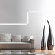 VIGO System LED-Linienmodul 100cm Alu-matt an einer Wohnzimmerwand mit eleganter Sofagarnitur und Vasen.