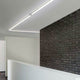 VIGO System LED-Linienmodul 100cm Alu-matt an einer modernen Wand mit Ziegelstein.