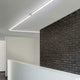 VIGO LED-Linienmodul 150cm in Alu-matt an einer modernen Wand mit Ziegelsteinverkleidung.