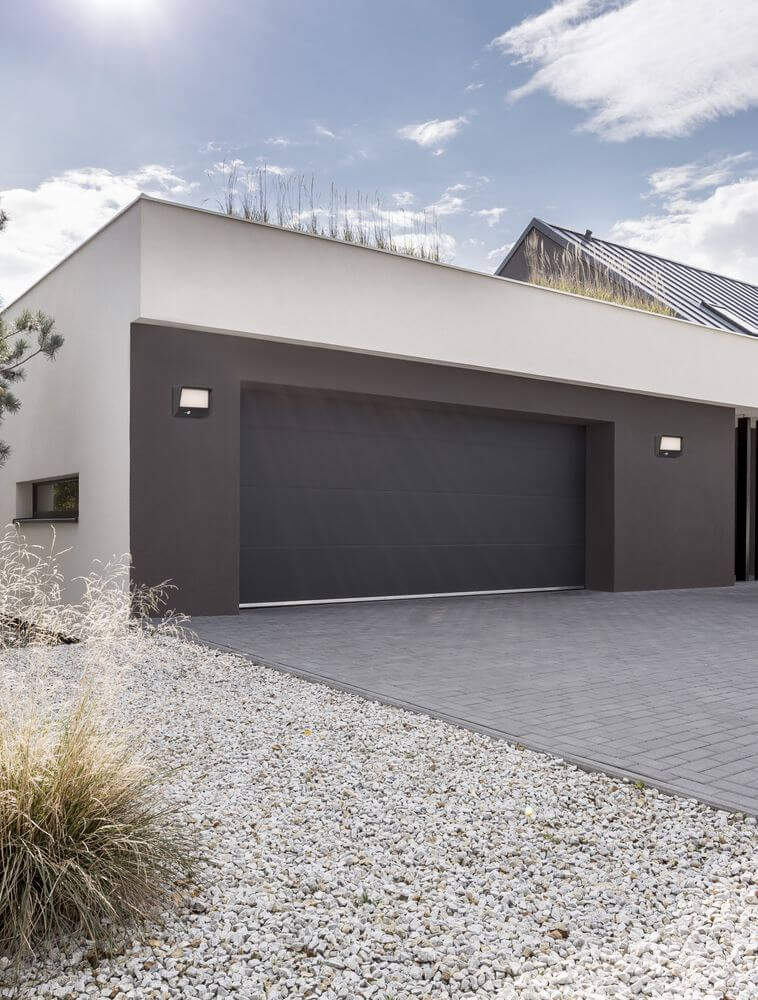 Valor LED Außenwandleuchte 3000K Anthrazit IP65 an moderner Fassade mit einladender Einfahrt.