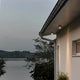 Varese LED Außen Deckenleuchte in Dunkelgrau an einem modernen Haus am Wasser, ideal für die Terrassenbeleuchtung.