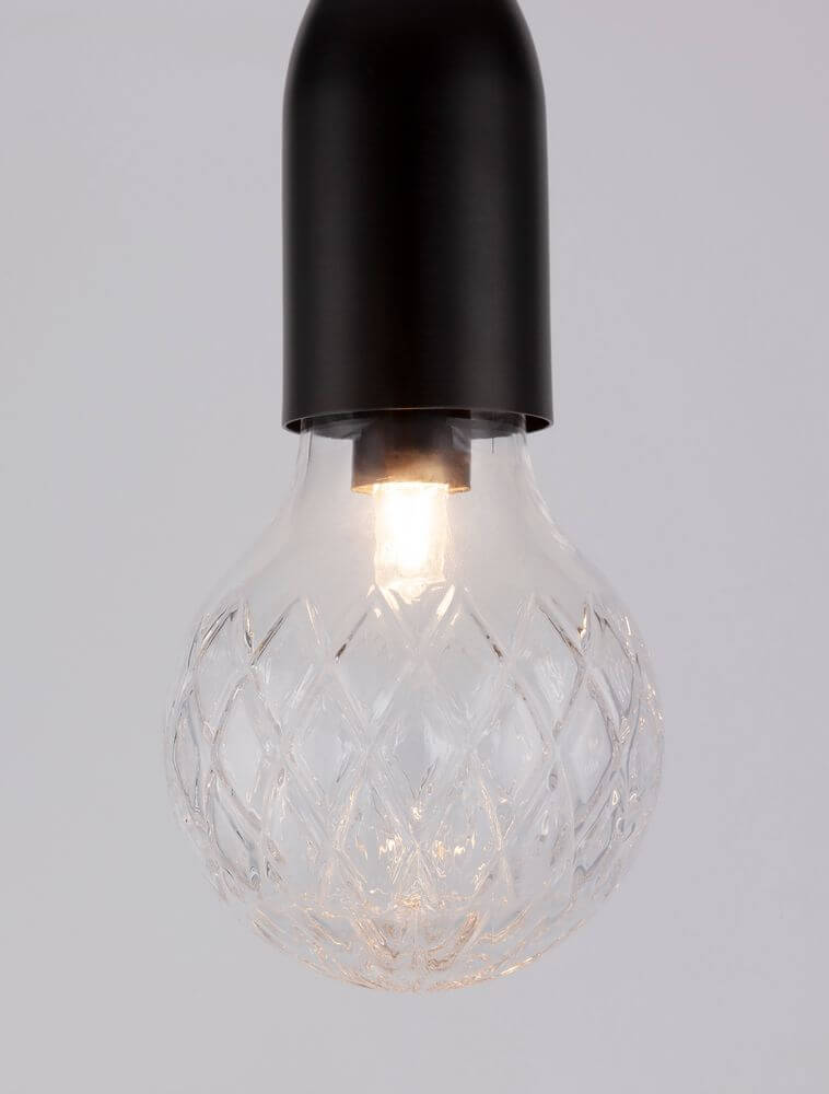 Schwarze Pendelleuchte mit klarer kugelförmiger Glühbirne und elegantem Kristallmuster.