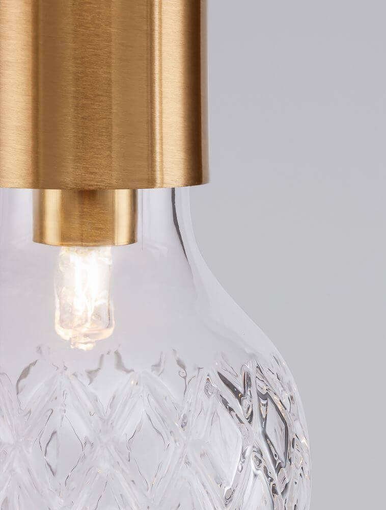 Detailansicht einer eleganten Pendelleuchte mit Glas und goldfarbenem Metall, ideal für stilvolle Innenräume.