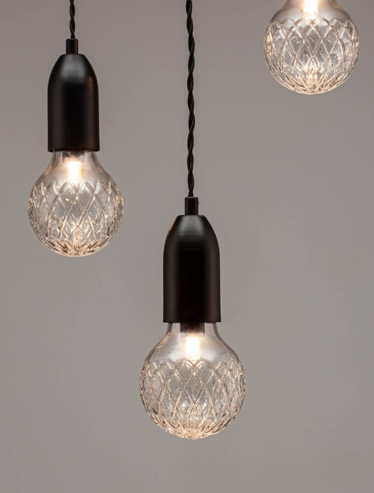 Elegante Veda Pendelleuchte mit klaren Glaslampen und schwarzem Metall. Ideal für modernes und klassisches Interieur.