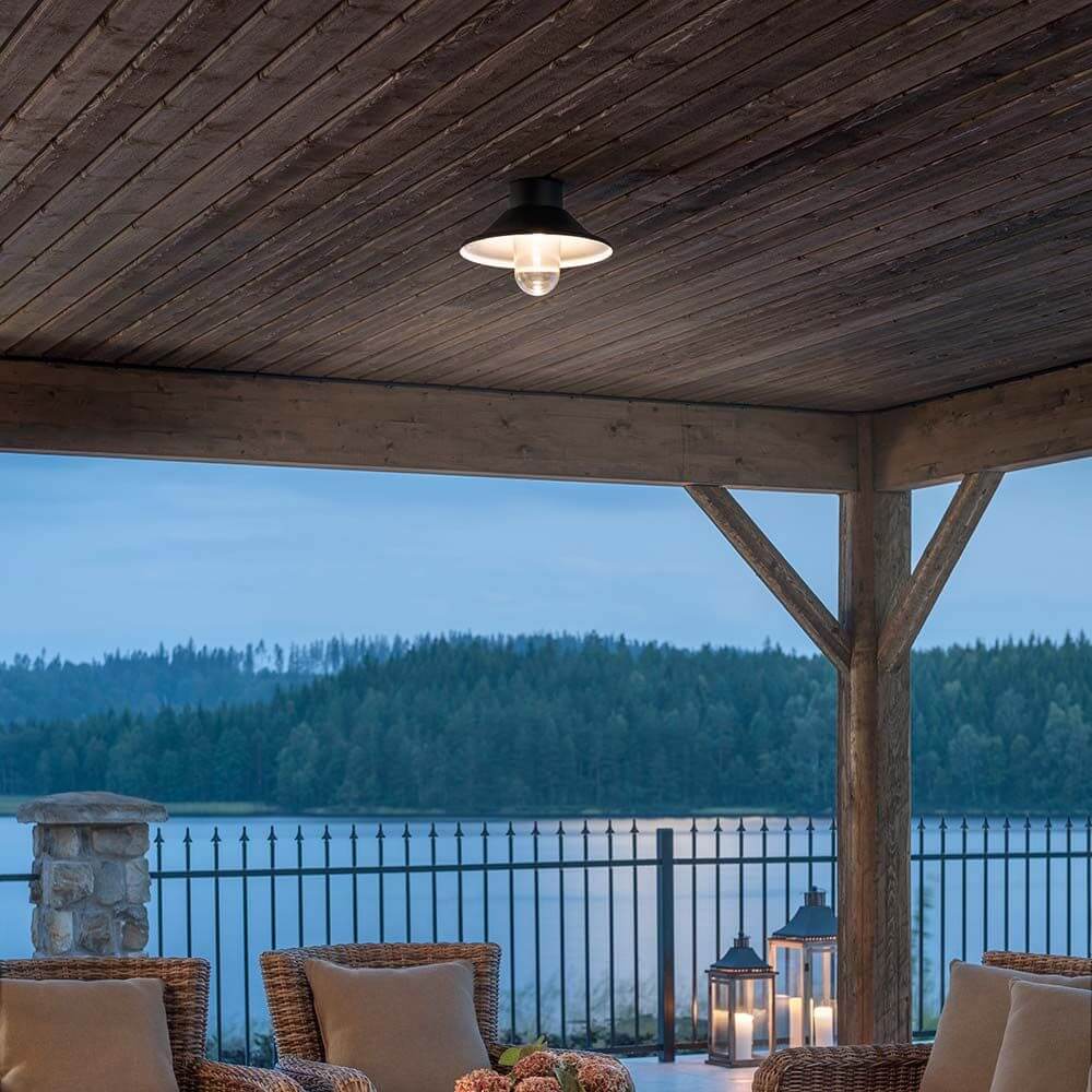 Vega LED Deckenleuchte 700lm 3000K Schwarz, klares Glas an einem Holzdecken-Pavillon mit Blick auf den See.