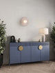 Vrahos Wandleuchte G9 Ø 29,5cm Beton Beige an modernem Sideboard mit Pflanzen dekoriert.