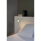 Spot Wandlampe ORLEANS Weiß an einem Bett mit weißer Bettwäsche und Nachttisch.