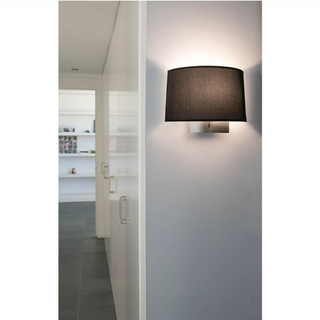 Wandlampe VOLTA Nickel, Schwarz an der Wand in einem modernen Innenraum, stilvolles Design.