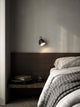 Wandleuchte Angle an einer Wand über einem Bett, modernes Design im Schlafzimmer von Maria Berntsen.
