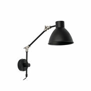 Vegglampe CELIA svart montert på veggen med fleksibel arm og moderne design.
