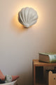Wandleuchte Konchi, elegante Muschel-Form, organisch geformter Metallschirm, diffuses Licht an der Wand.