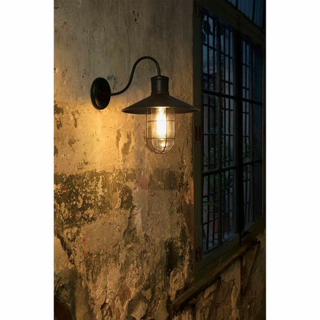 Wandleuchte MARINA Schwarz an einer Wand mit vintage Charakter, strahlt warmes Licht aus.