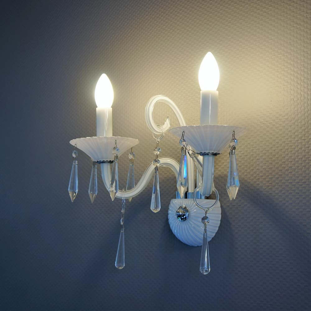 Wandleuchte Rosano 2-flammig Weiß mit zwei transparenten Glühbirnen und dekorativen Kristallanhängern.